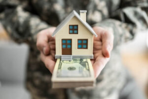 Military member holding model of a house.