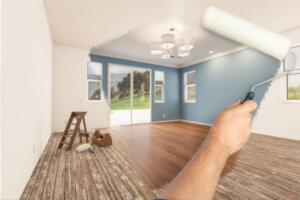 Before and after of man painting roller to reveal newly remodeled room.