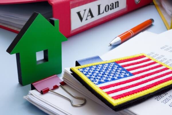 Model of house, flag and papers with VA loan.